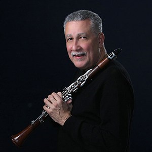 Paquito D'Rivera portrait with black background holding clarinet