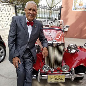 Paquito D'Rivera standing next to red convertible