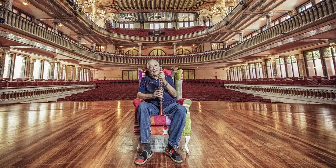 Paquito D'Rivera sitting on stage in auditorium