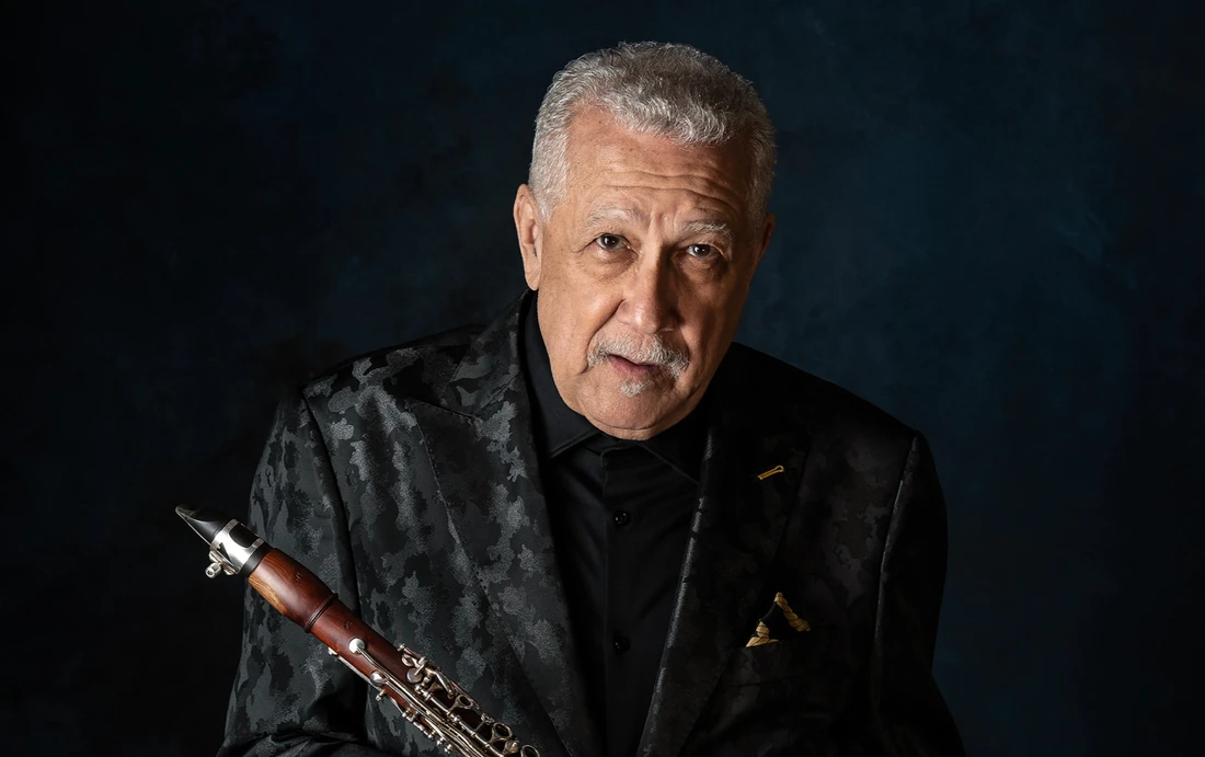 Paquito D'Rivera in black suit holding clarinet - photo credit Geandy Pabon